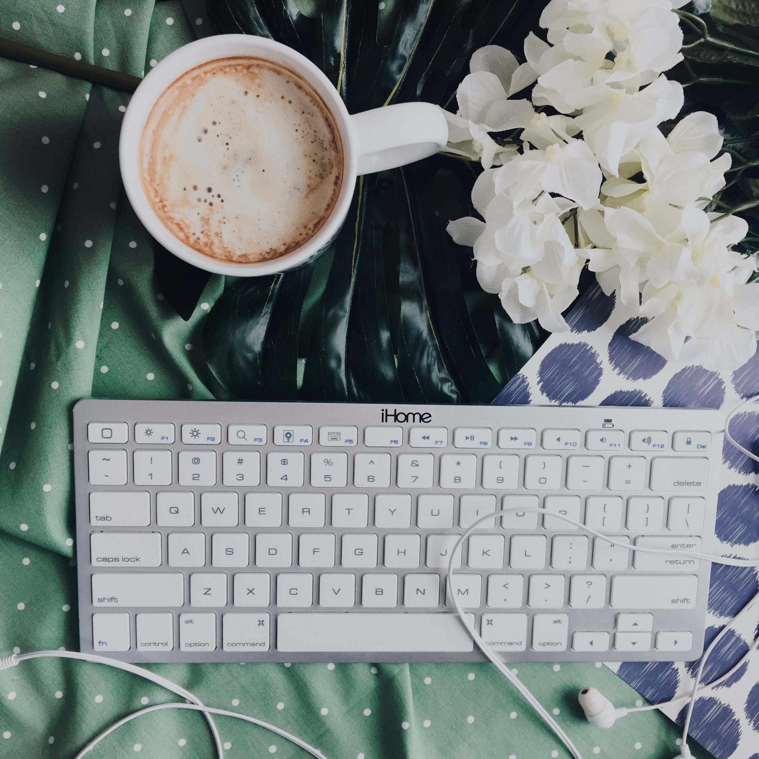 keyboard coffee and flowers on multi color background